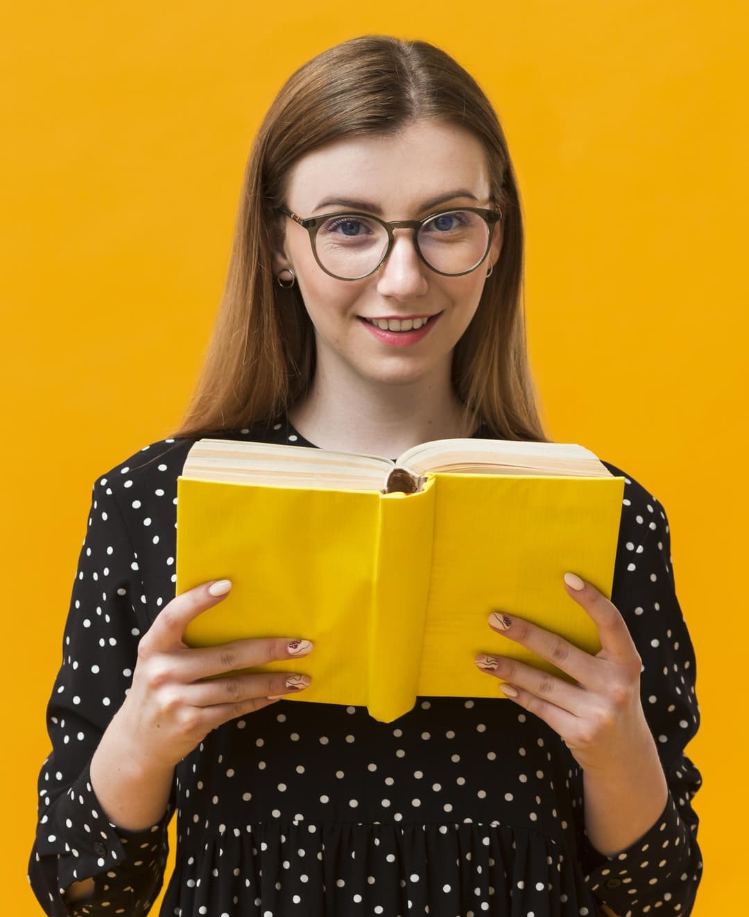 an girl holding a yellow book while looking at you